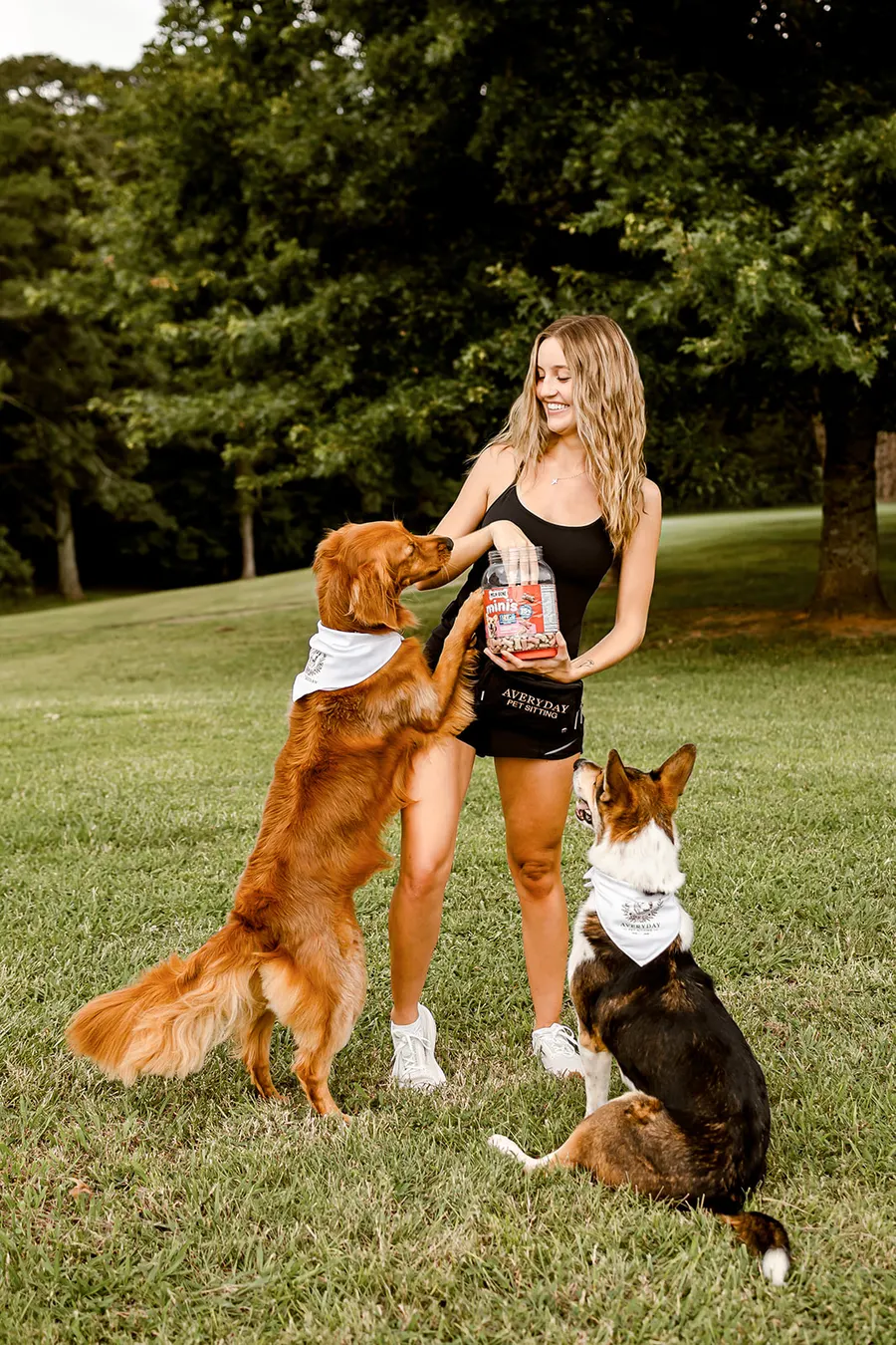 Avery smiling as she hands out treats to both dogs